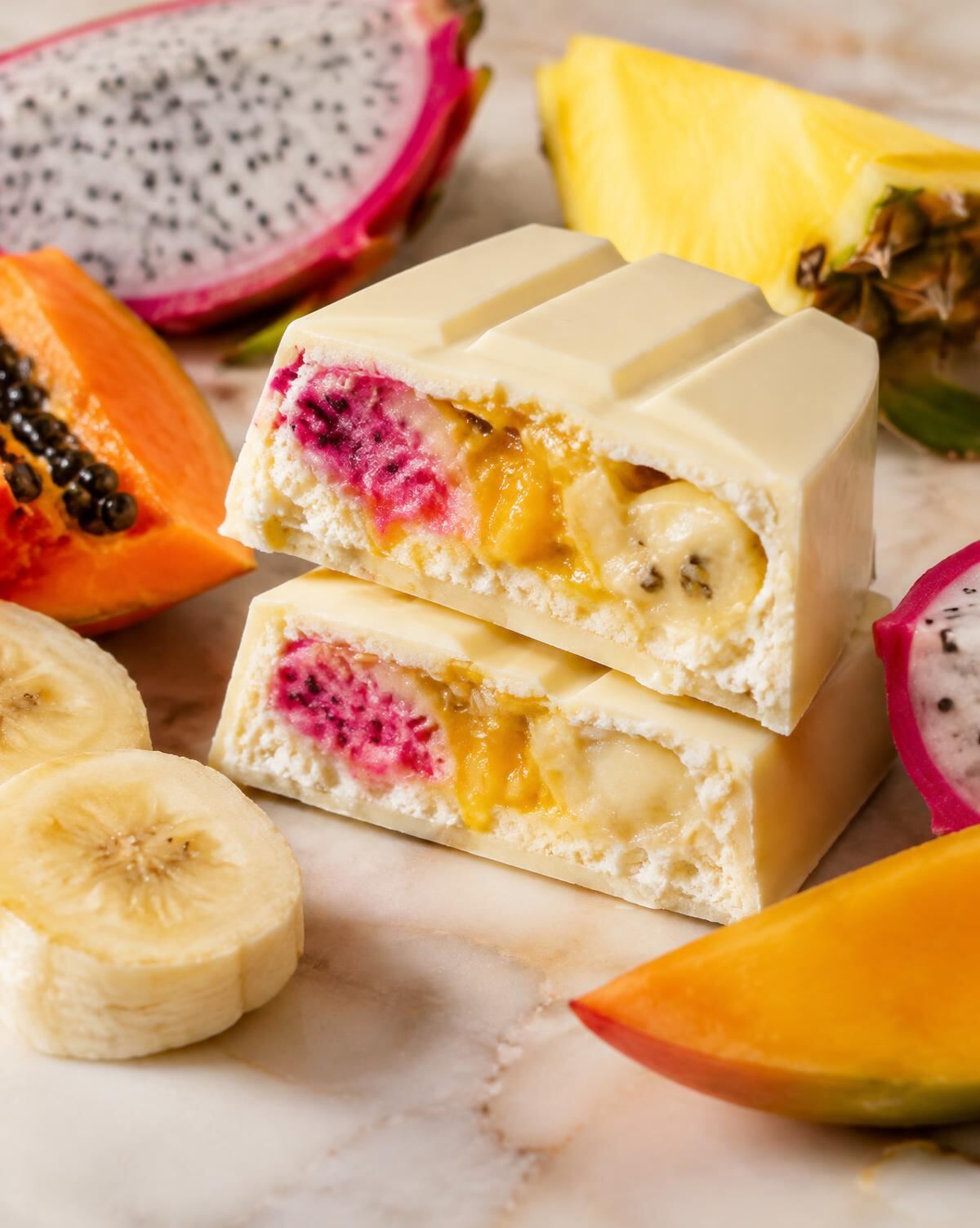Chocolat blanc garni de fruit du dragon, mangue et banane, entouré de fruits tropicaux
